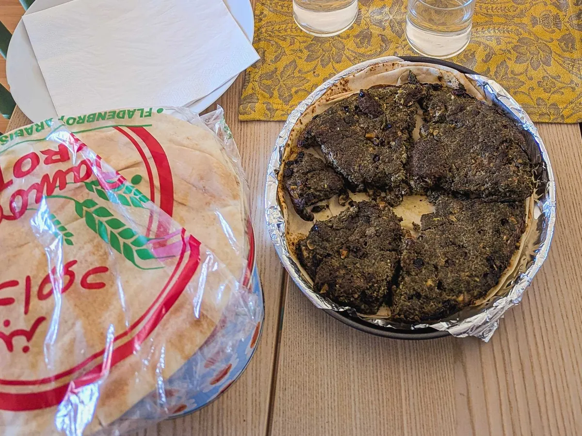 A plate of kuku sabzi next to a package of flatbread.