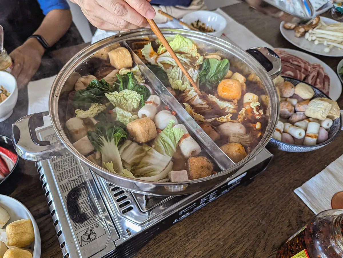 Cooking the ingredients inside the hot pot, which has two compartments.