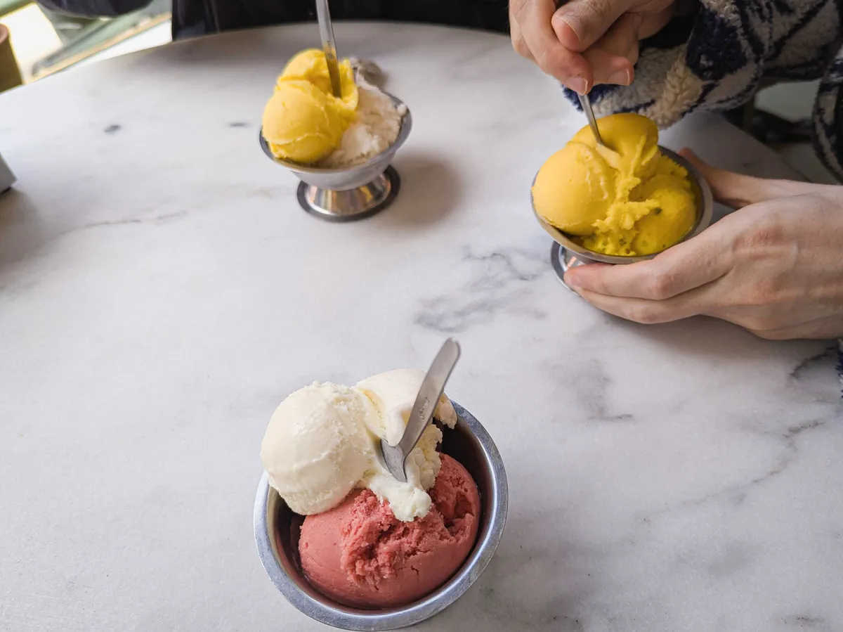 3 small stainless steel ice cream bowls containing two scoops of ice cream each.
