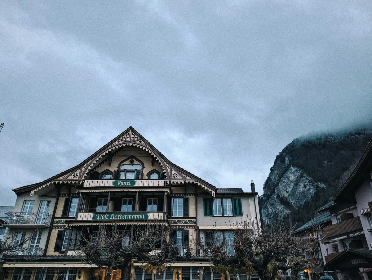 A wooden Swiss-style chalet with ornate decorations around the roof.