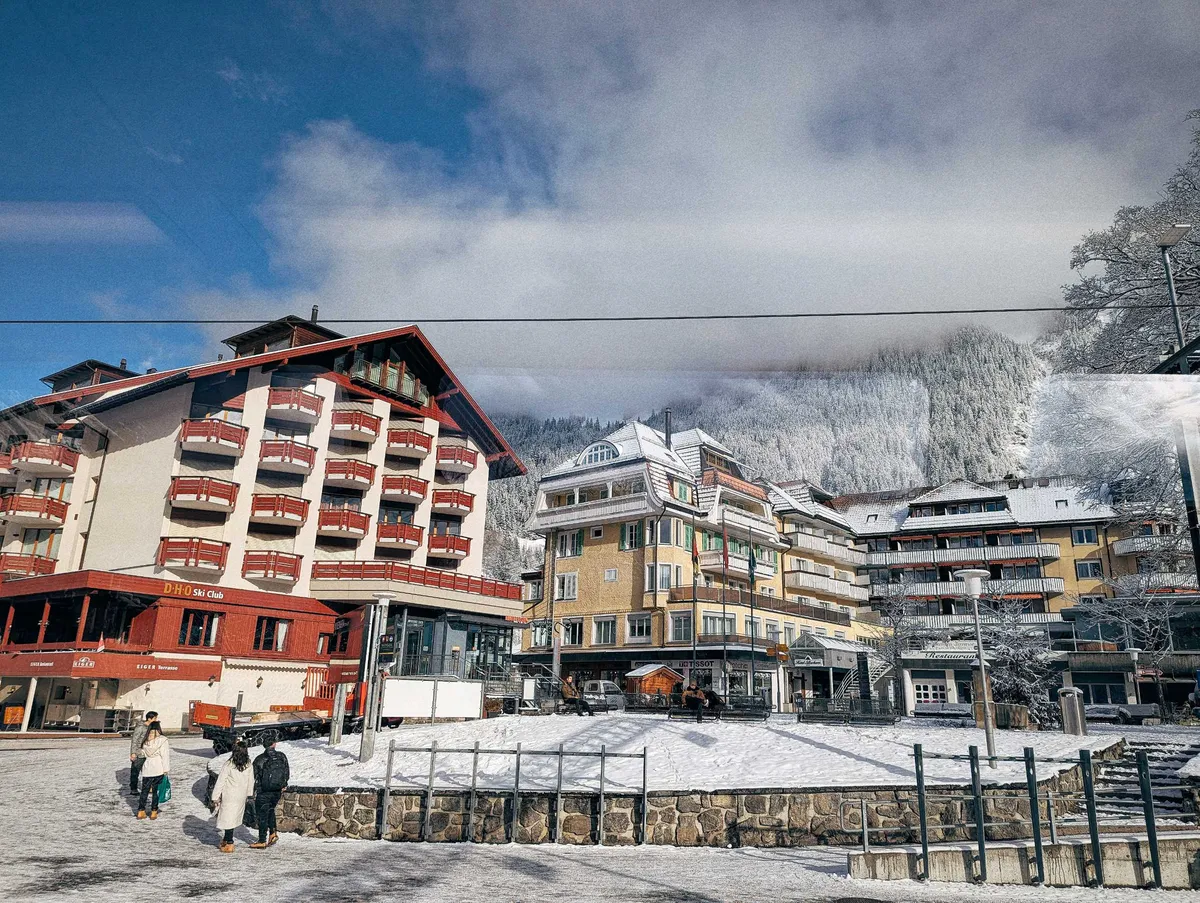 A view of hotel-like buildings. The ground and rooftops are covered in snow.