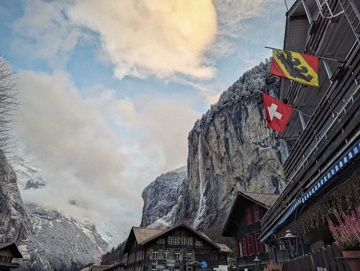Views of the wooden buildings, with one hanging a Swiss flag and a Bern flag right next to it.