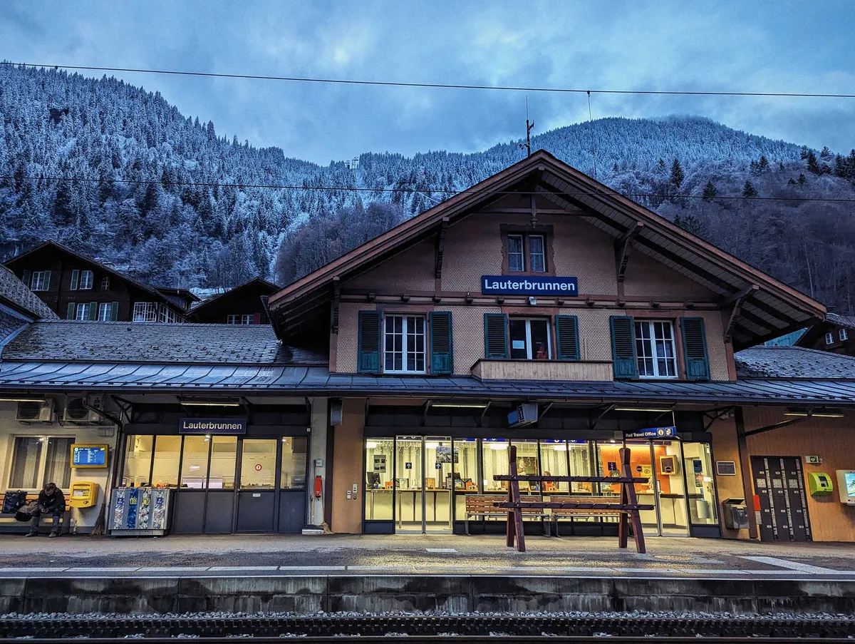 Lauterbrunnen station. The top of the building has a slanted roof, like that of old wooden Swiss buildings. The lower half is more modern.