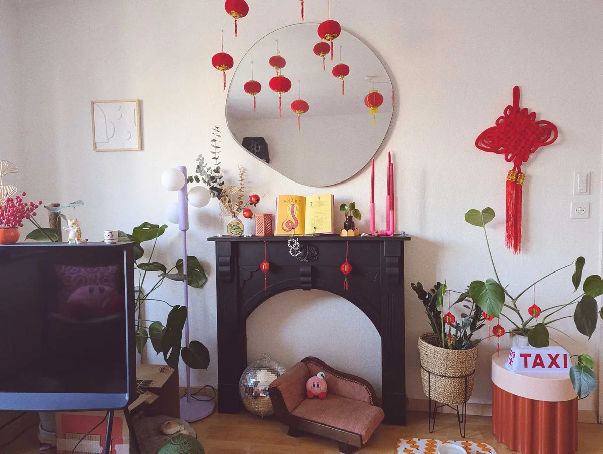 A living decorated with lots of red lanterns, pink accents, and Kirby plushies.