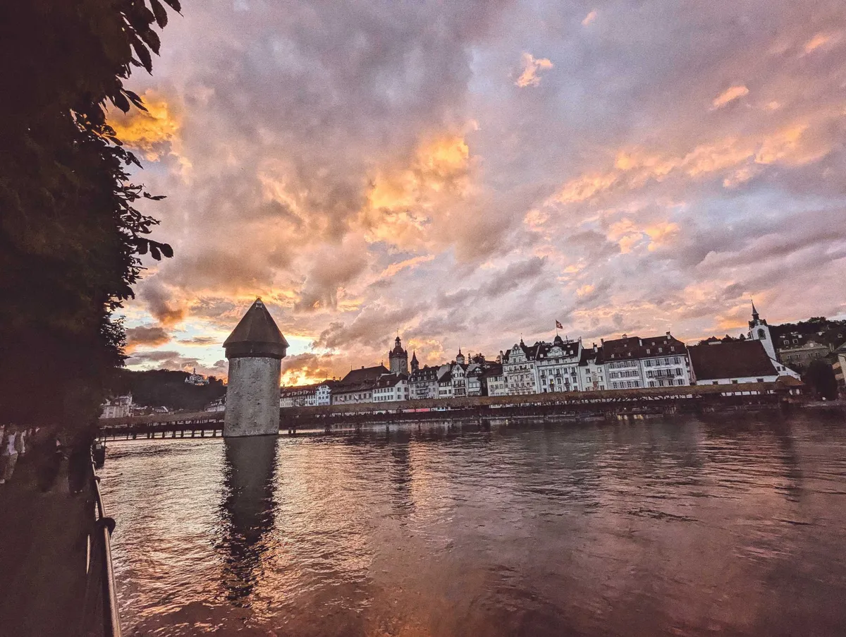 Lucerne's Kapellbrücke with a rosy sunset in the background, highlighting the clouds.
