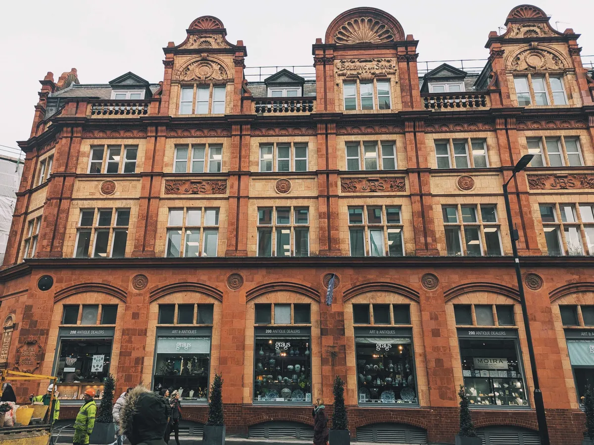 A large reddish brick building with ornate decorations built in.
