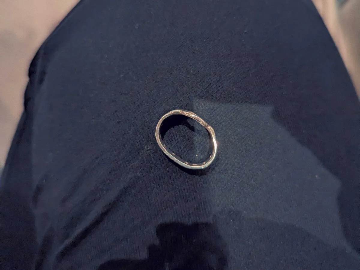 A silver ring that has been misshapen.