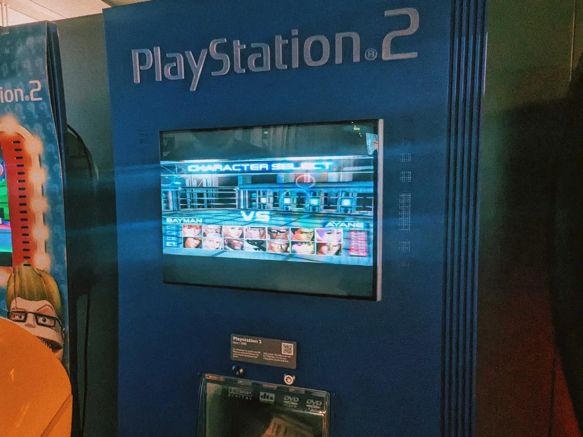 A Play Station 2 display with an LED screen embedded and the character selection screen of "Dead or Alive" displayed.