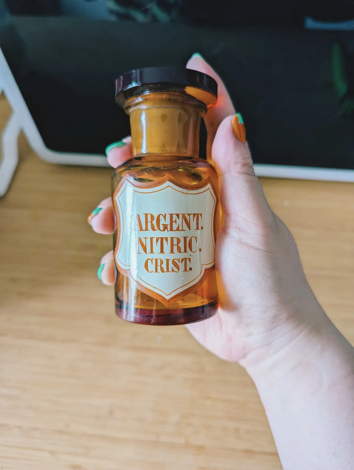 Peige holding a brown medicine bottle with the label 