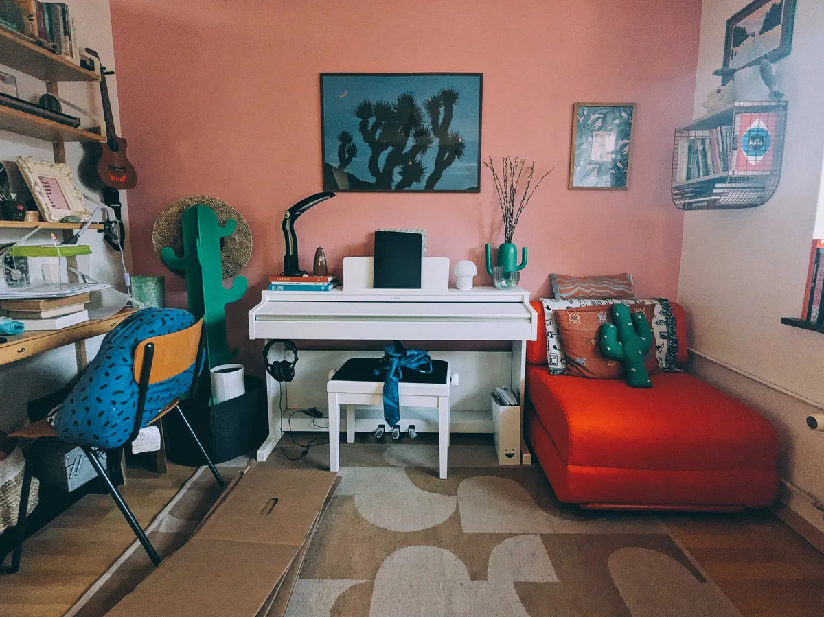 A clean office with a red chair-bed in the corner.