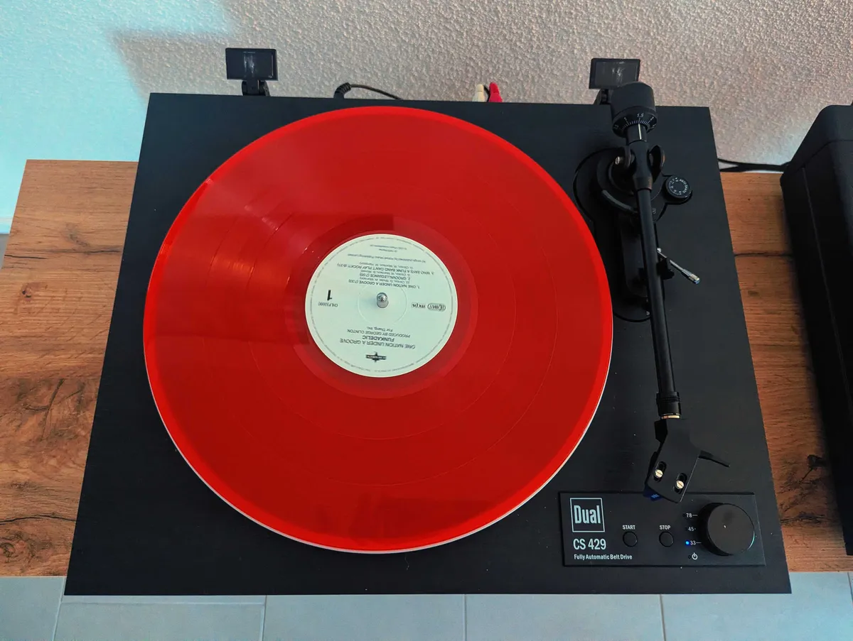 A red record on a black, open-faced record player.