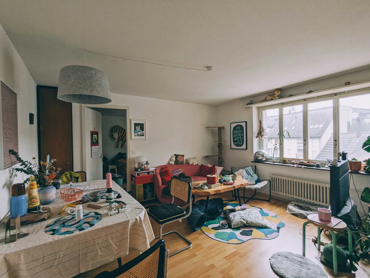 Living room with small areas of clutter, like on the dining table and coffee table.