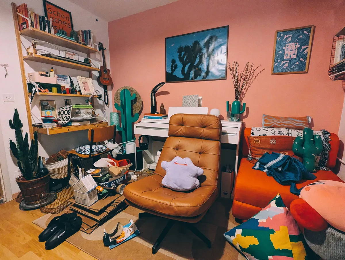 A cluttered office, including the return of a brown leather recliner with a smiling Ditto plushie.