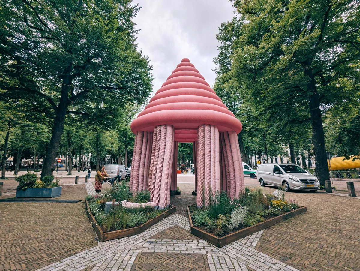 A giant, inflatable pink gazebo surrounded by plants.