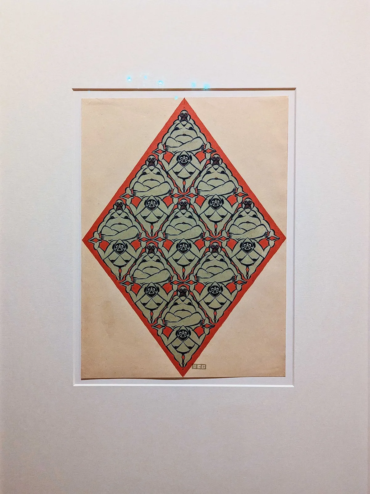 A pattern of humans inside a red diamond. This piece is titled, 