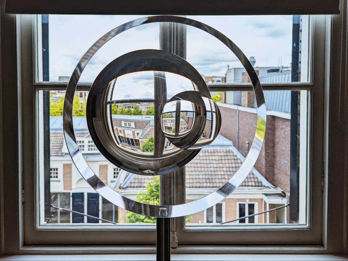 Glass circles that are overlayed on top of each other in front of a window, created a distorted view of the outside.