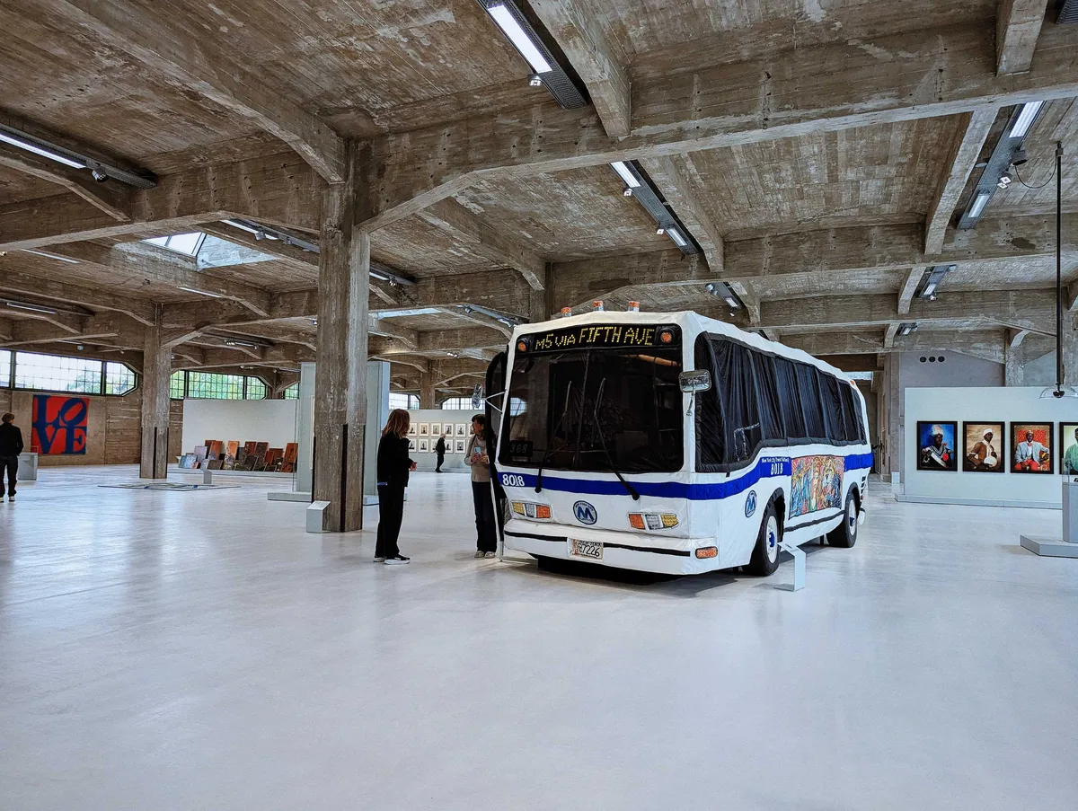 A life-sized bus made out of fabric is placed inside the large gallery space.