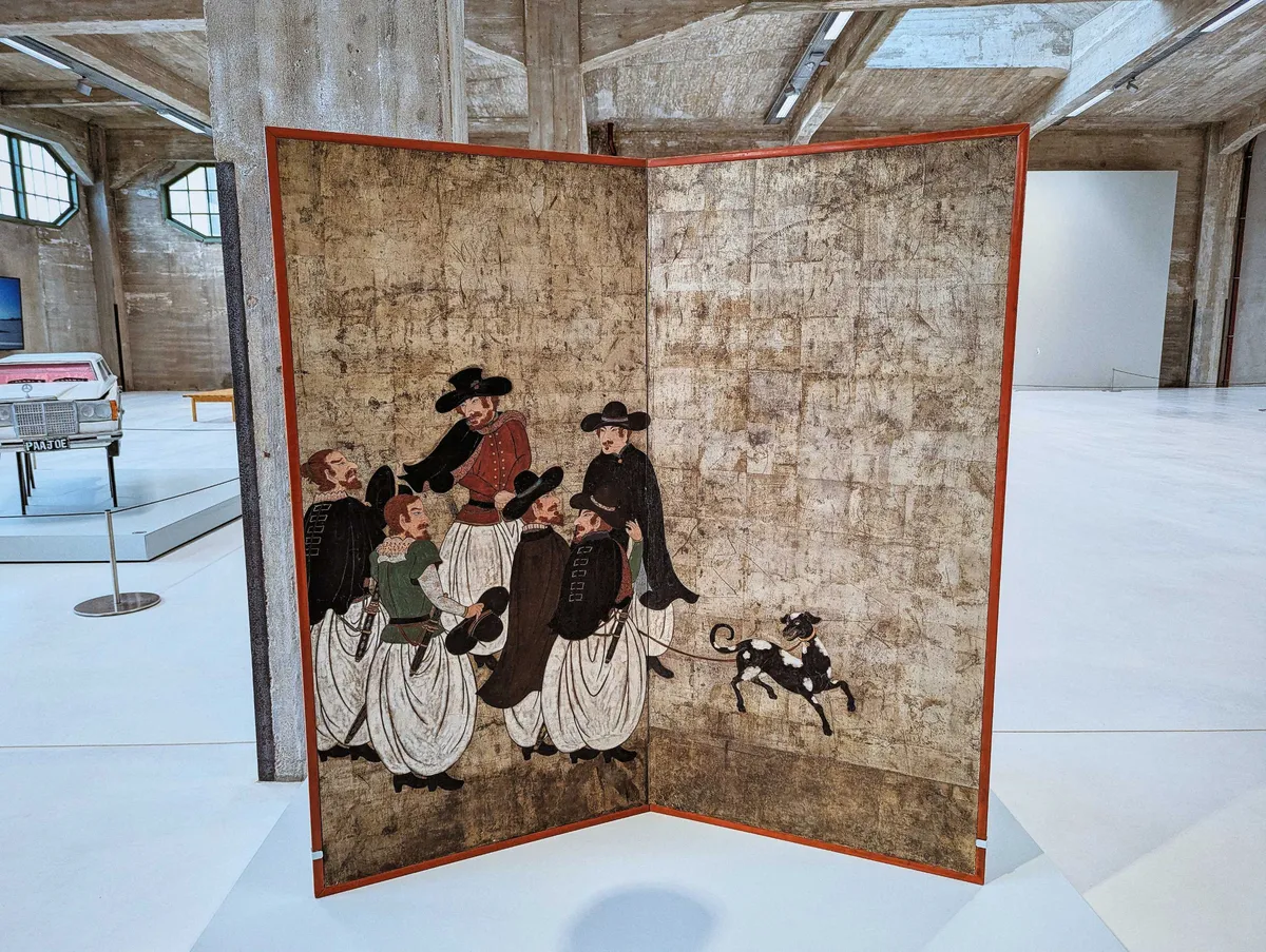 A large panel with a Japanese painting of red-haired, Western men wearing baggy white pants and black hats standing together, leading a black dog with white spots on a leash.