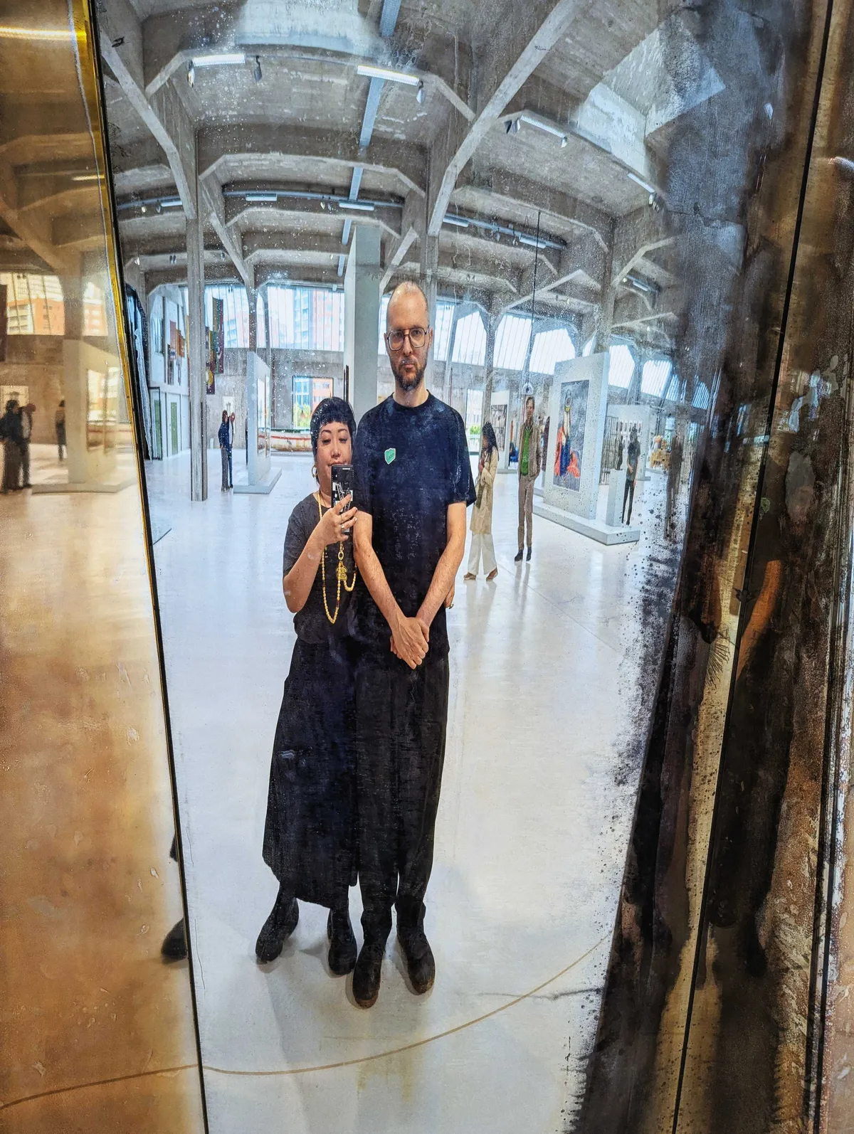 Peige and Daniel pose in front of their distorted reflection inside the exhibit.