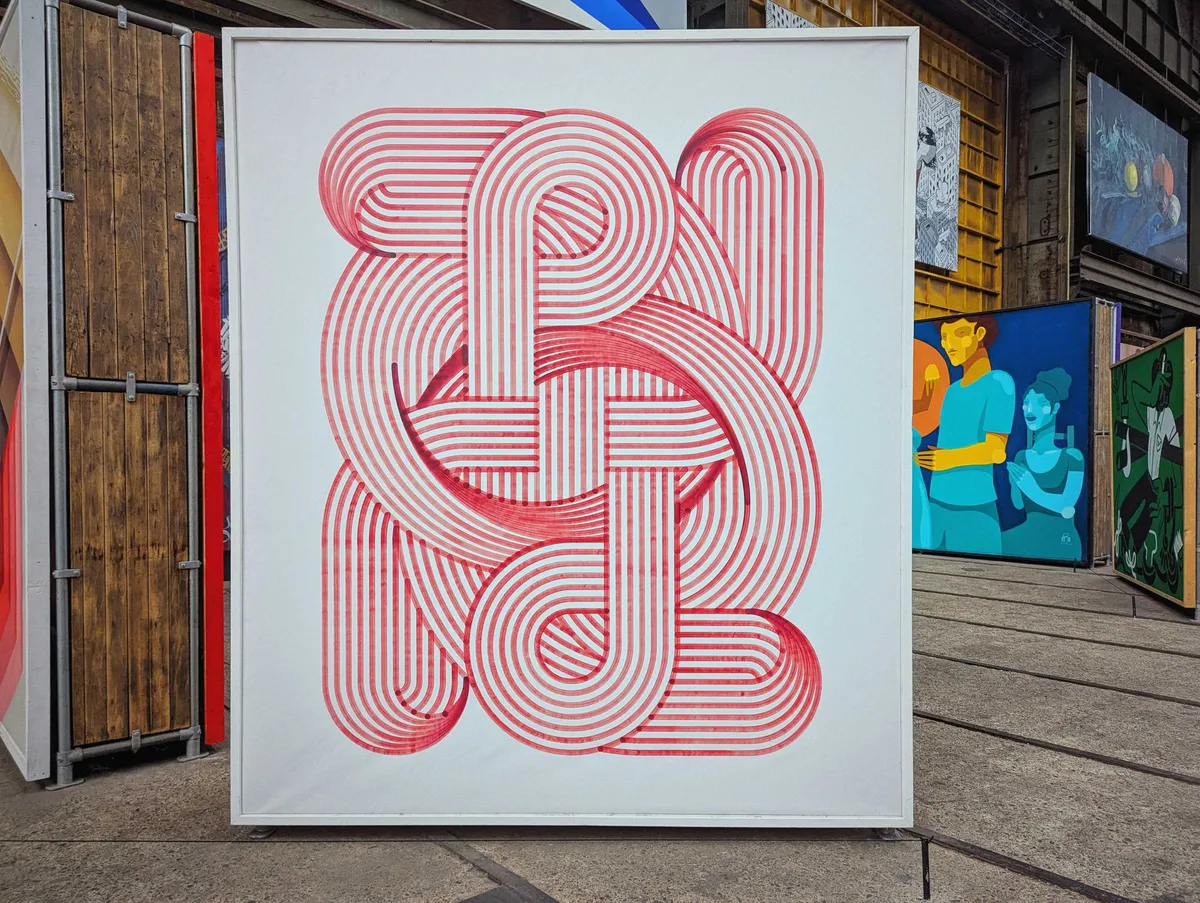 Ligature#29 by Antigoon, featuring intricate, interwoven red lines that create a continuous geometric looping pattern on a white background.