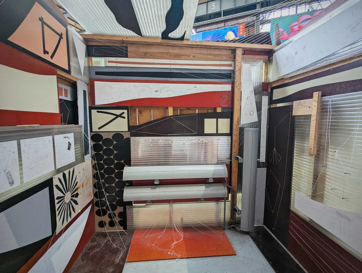 The interior of the structure filled with more salvaged pieces. Some areas have been painted white, encouraging visitors to leave their mark.