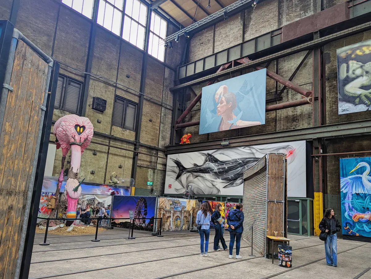 Graffiti art on distinct panels are hung from floor to ceiling inside this large warehouse.