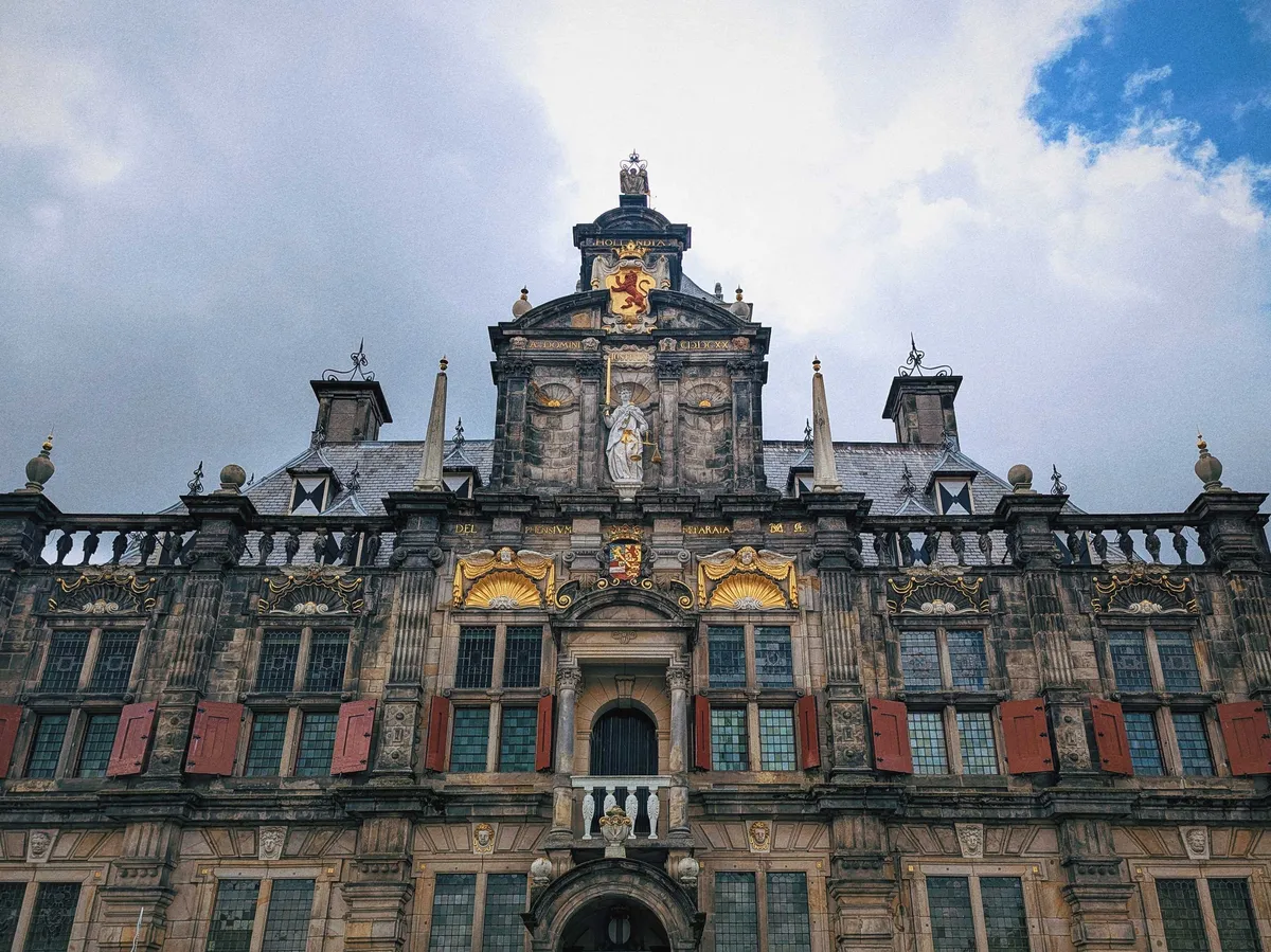 The front of Delft City Hall, with ornate gold motifs near the towers.