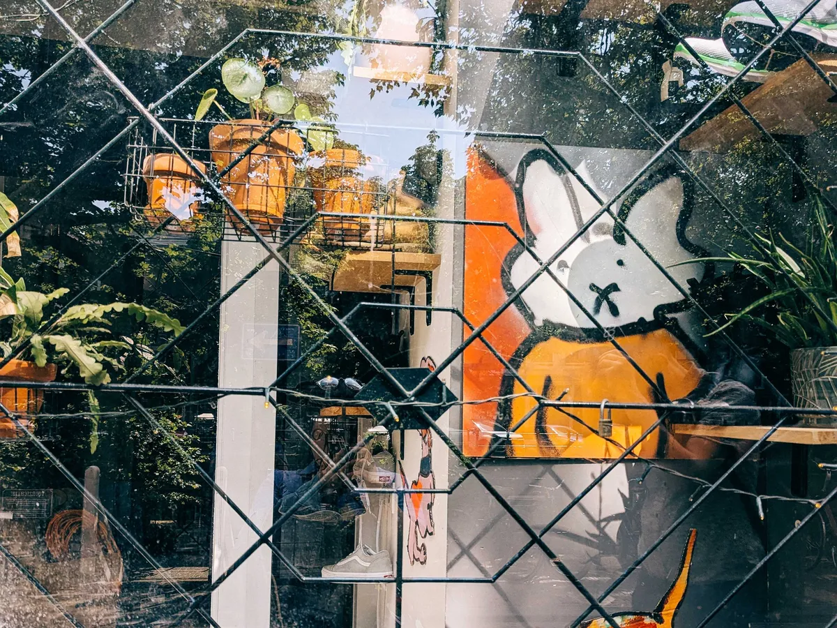 A painting of Miffy, done in the style of graffiti art, on canvas. Miffy is wearing an orange shirt and the background color is divided diagonally in half. One side is orange and the other is white.