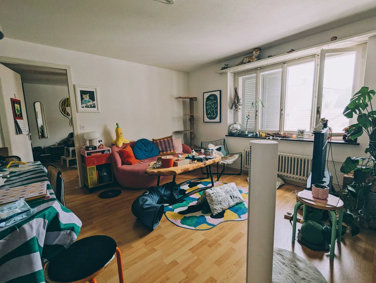 A living room with clean floors, though the coffee table looks a little cluttered.