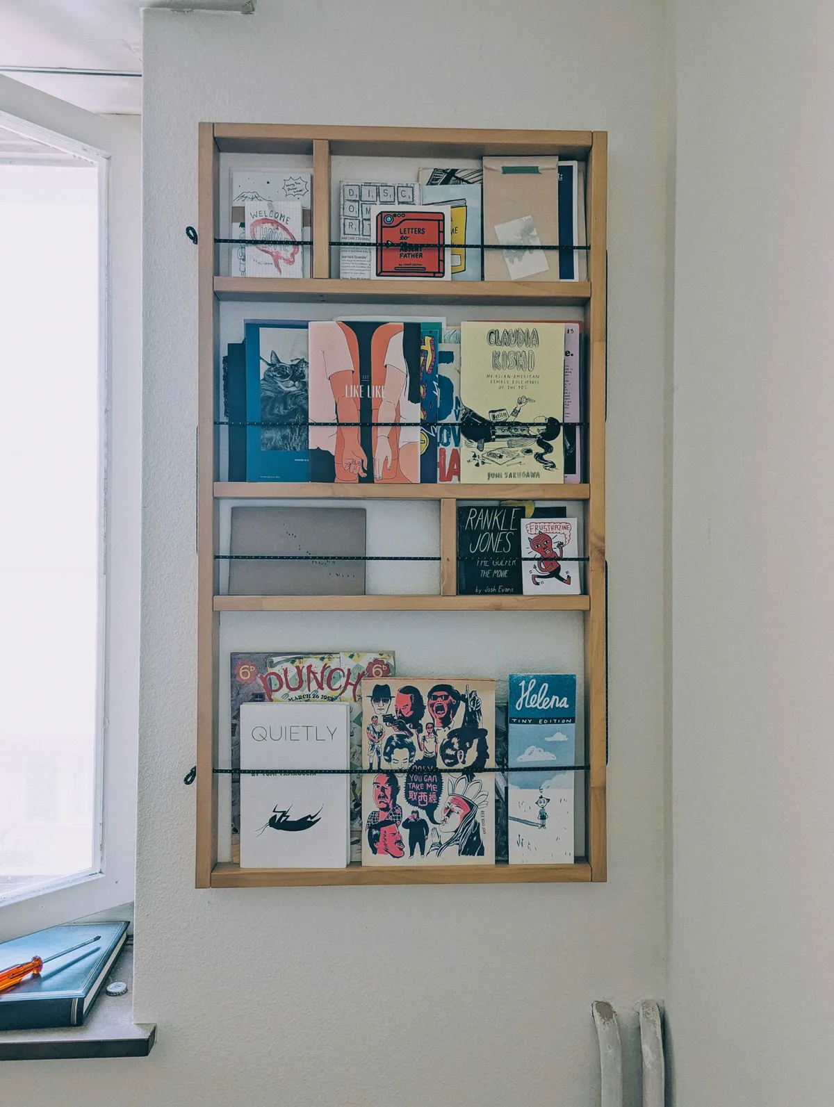 A close-up of the shelf, now filled with zines.