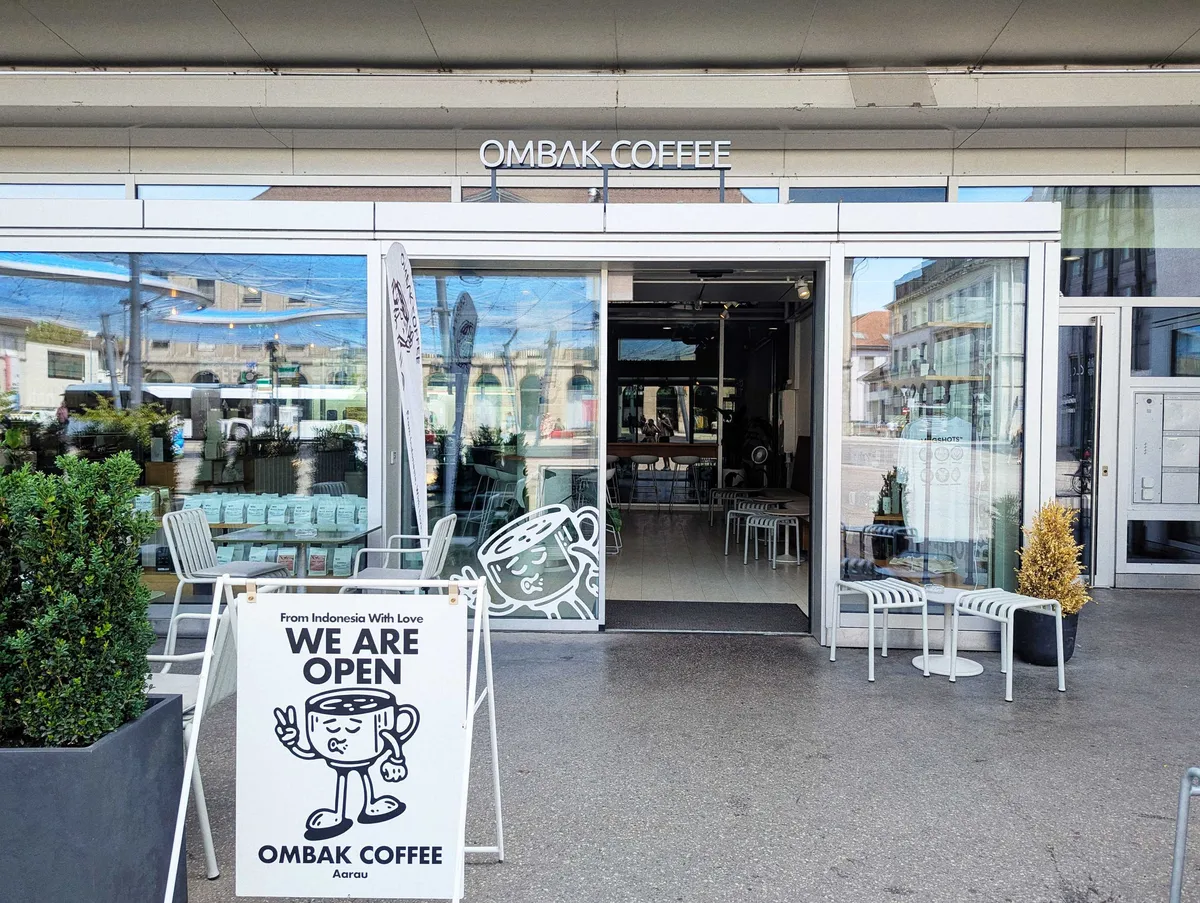 Exterior of the coffee shop, with a white placard stating, 