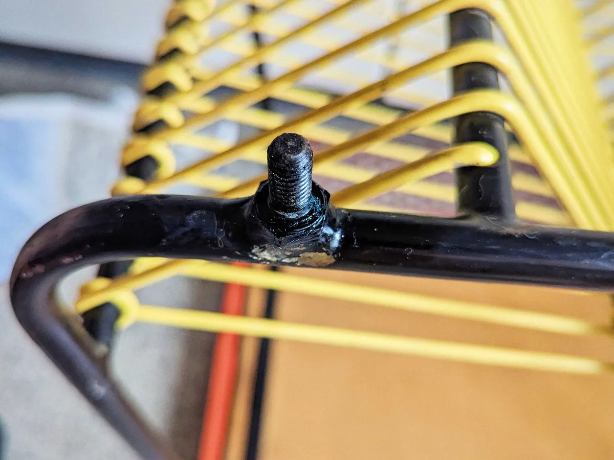 A threaded screw on the metal leg of the cart.