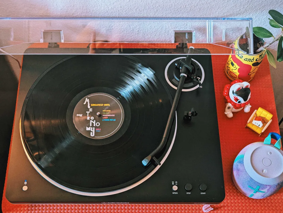 A record player on a red table spinning 