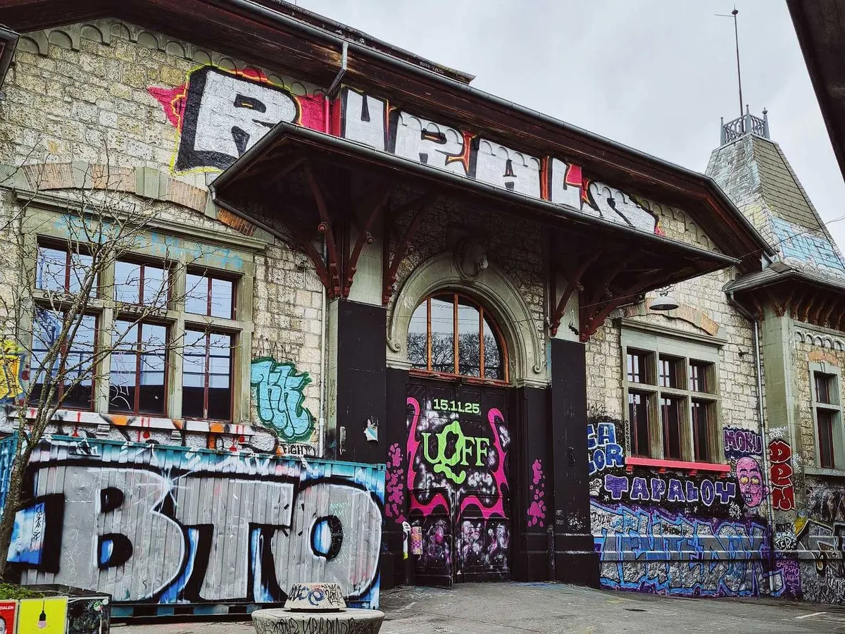 A colored photo showing the main door of the building covered in graffiti on the bottom half.