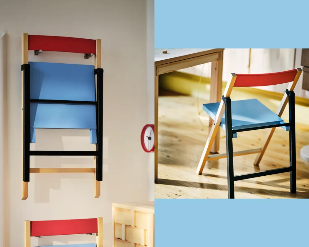 A folding chair with a light blue seat, black back legs and birch front legs, and a slim red back.