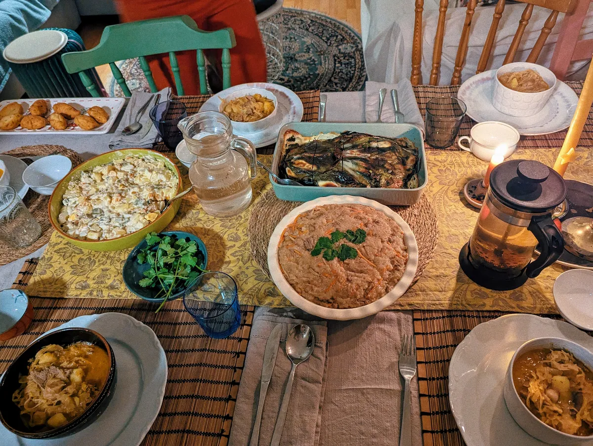 Plates of warmly-colored food are displayed around the table.