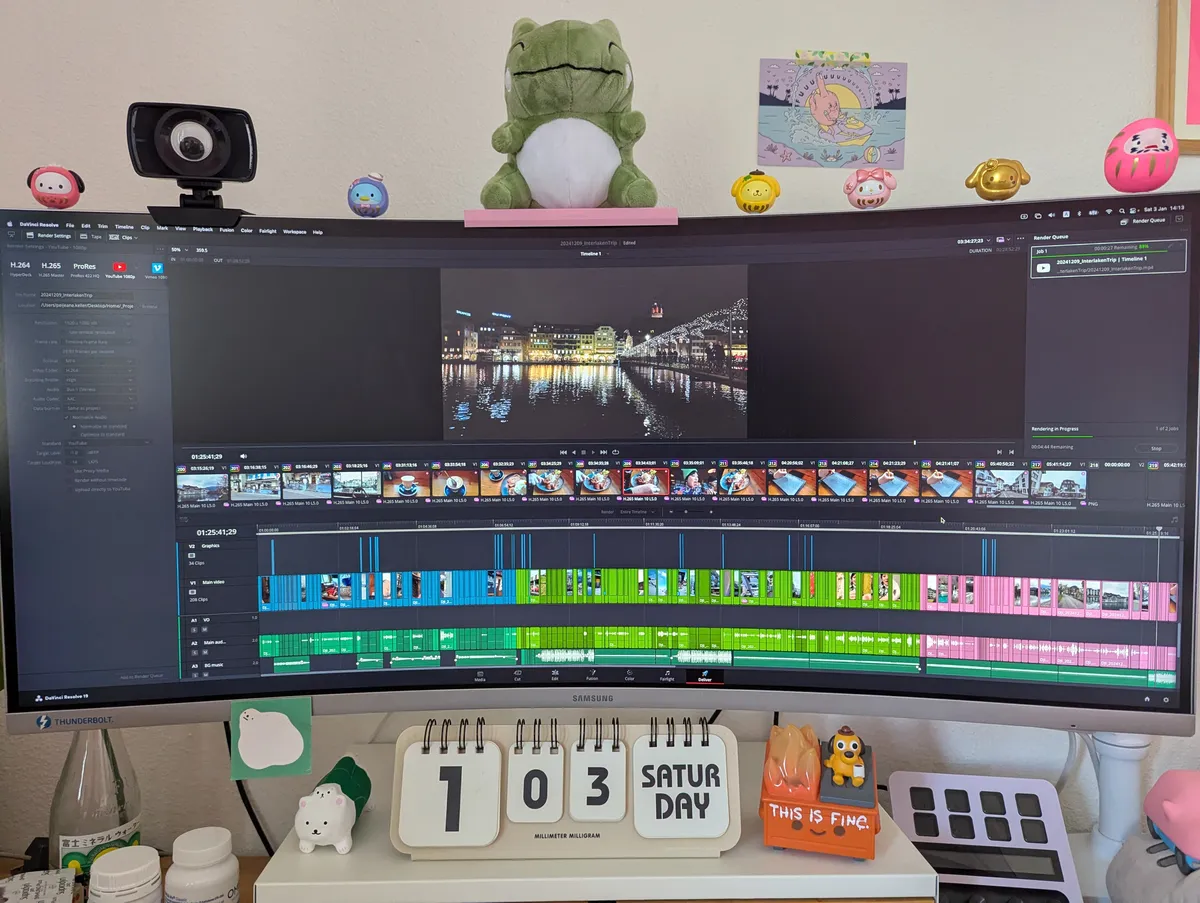 A wide monitor displaying a video editing interface. The top edge of the monitor is decorated with little darumas of Sanrio characters.