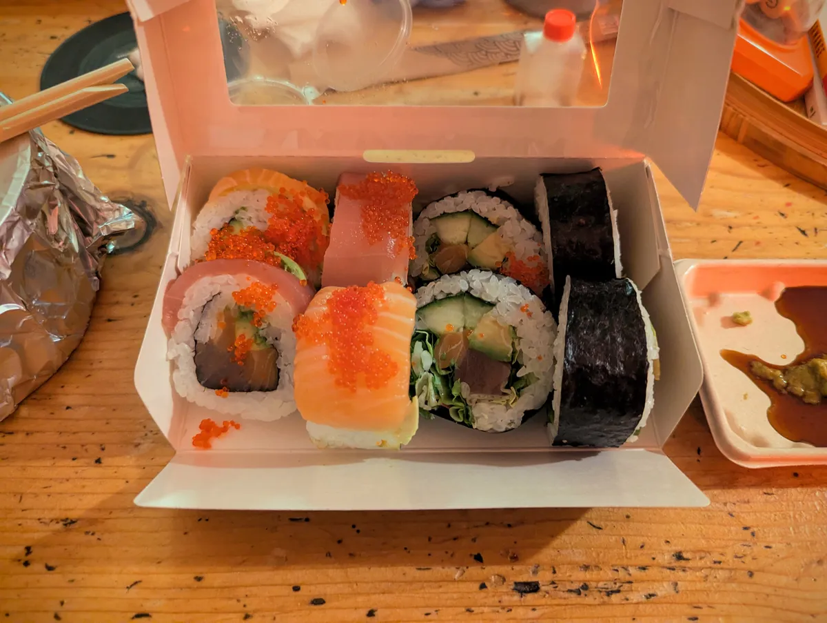 A takeaway container with assorted sushi.