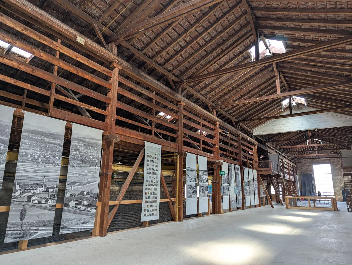 A large barn/warehouse with high wooden ceilings and concrete flooring.