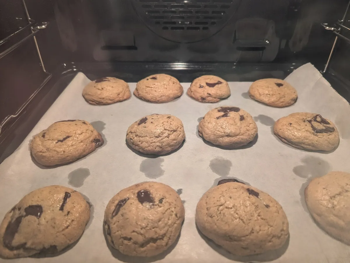 A tray of chocolate chip cookies baking in the oven.