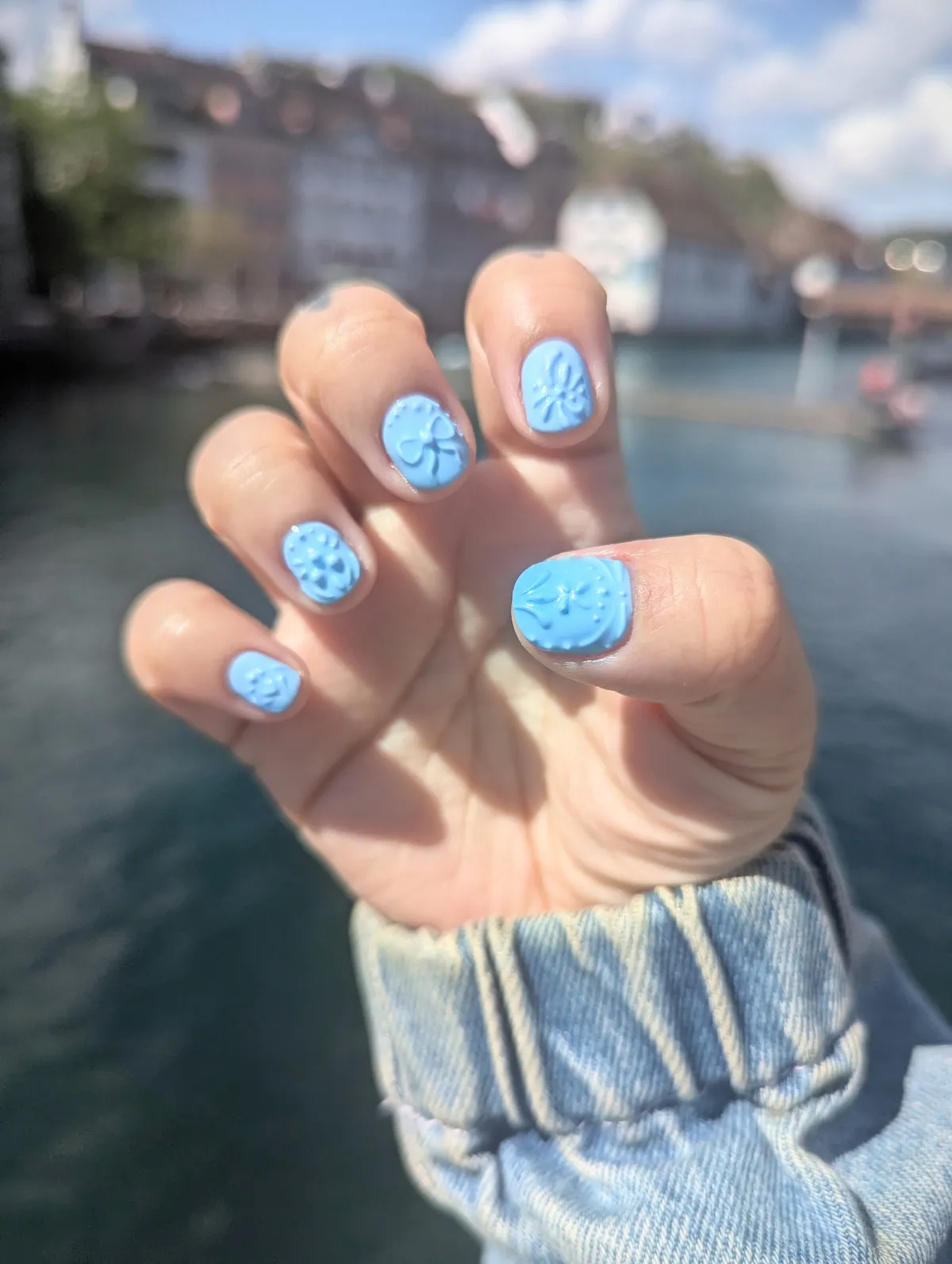Peige showing off their pale blue manicure with 3D art of dainty bows and flowers.