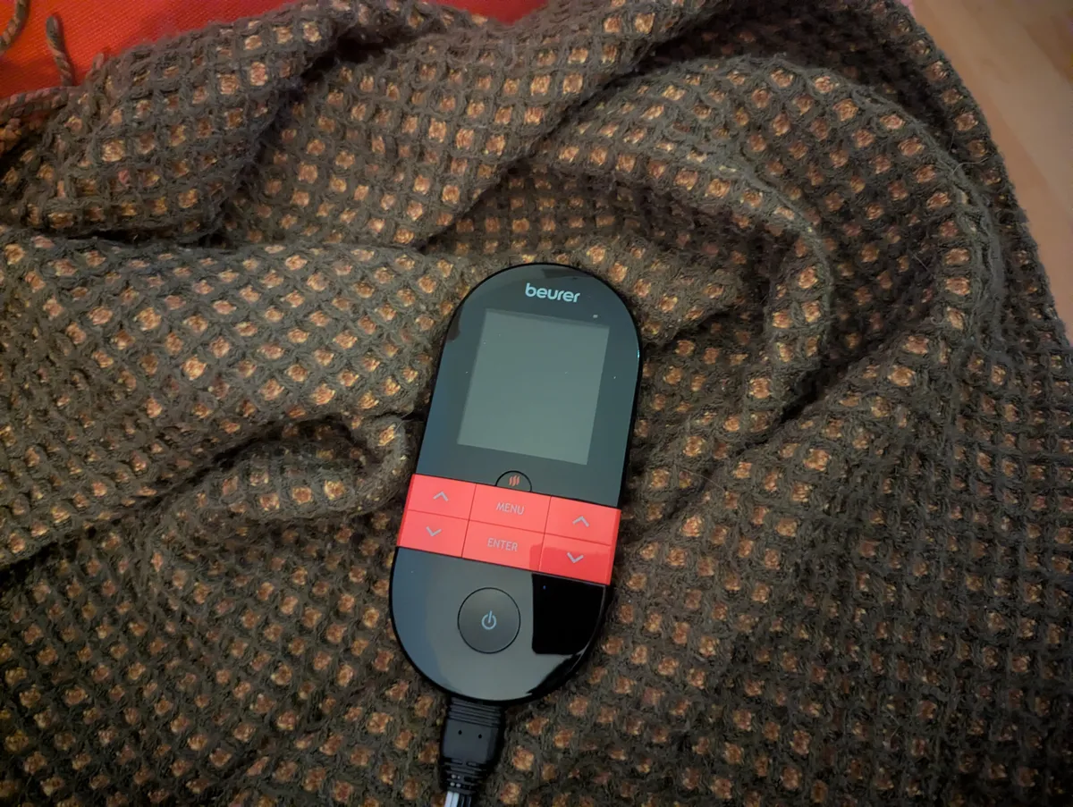 A device that looks like a remote with a screen. The brand is Beurer.