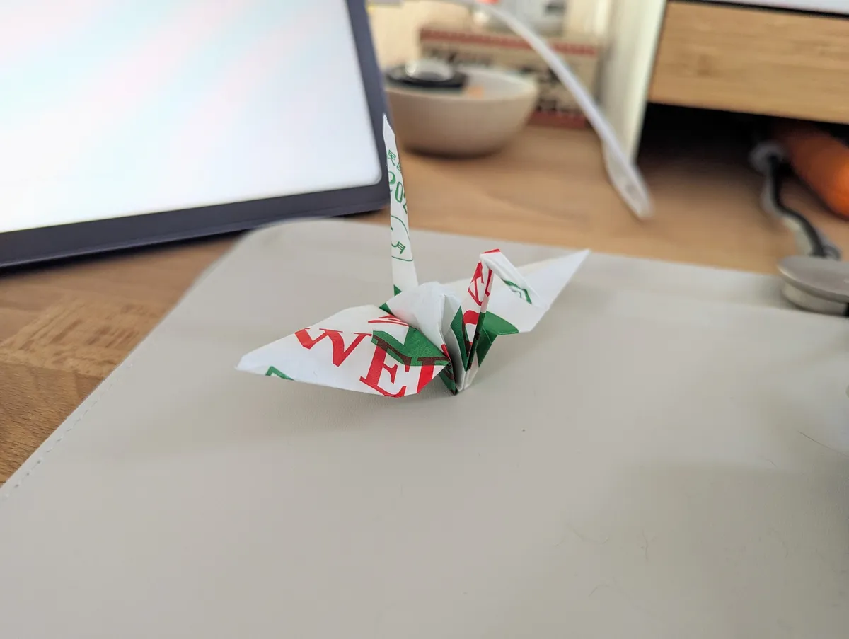 An origami paper crane made out of a tear-off calendar sheet.