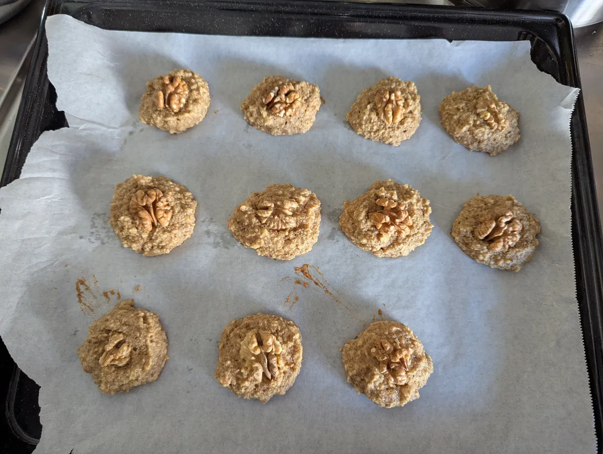 Walnut cookies cooling on a baking tray.
