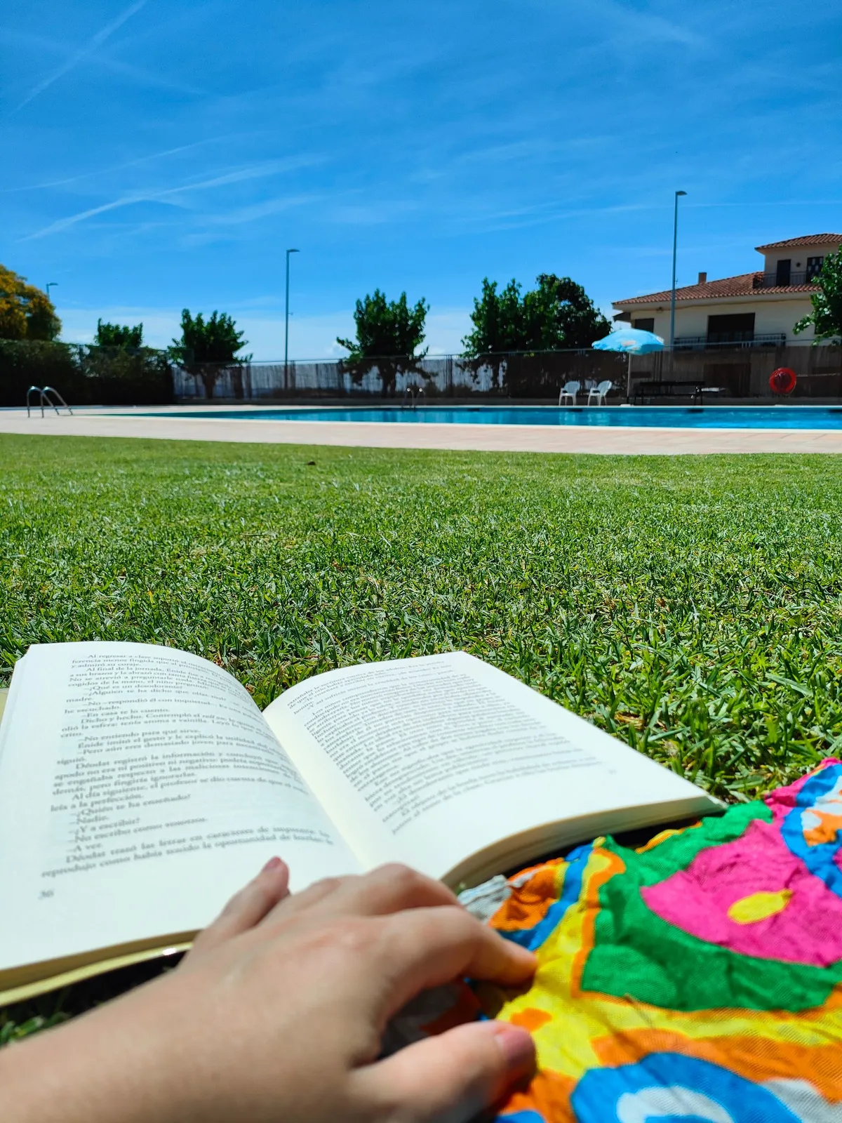 foto de un libro sobre la grama mirando una piscina-jpeg