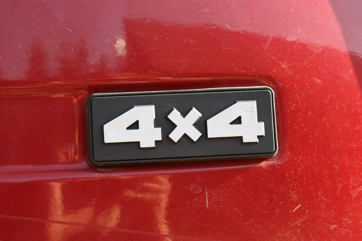 A close-up of a red vehicle's rear badge displaying 