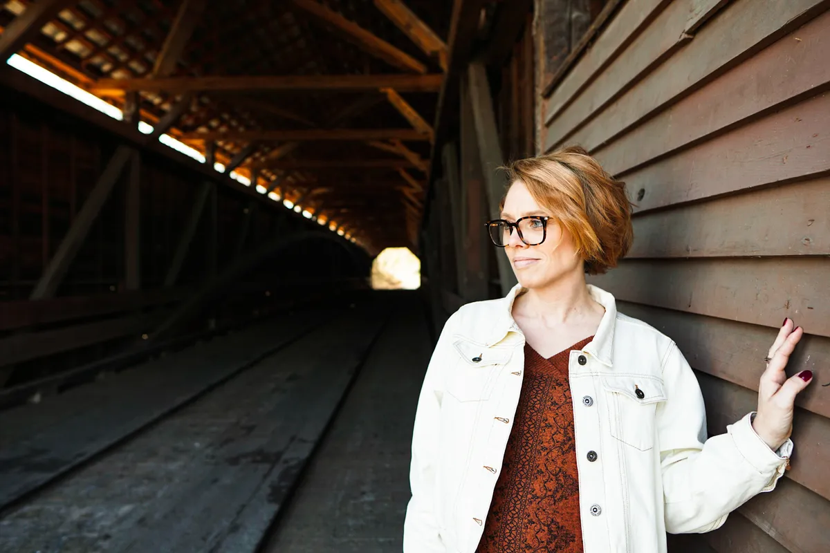 my wife standing in front of the entrance to a covered bridge