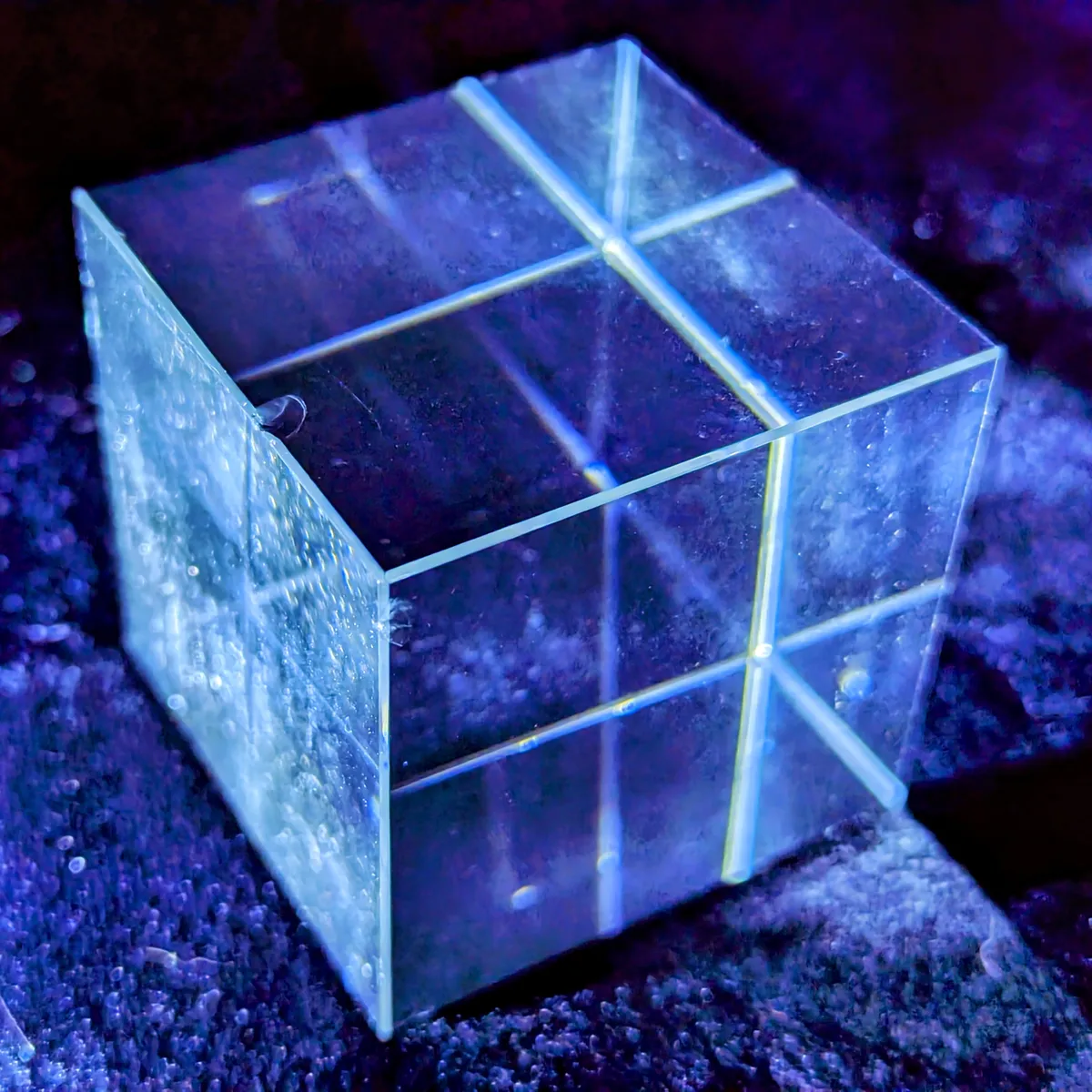 a transparent cube with blue lights shining through it