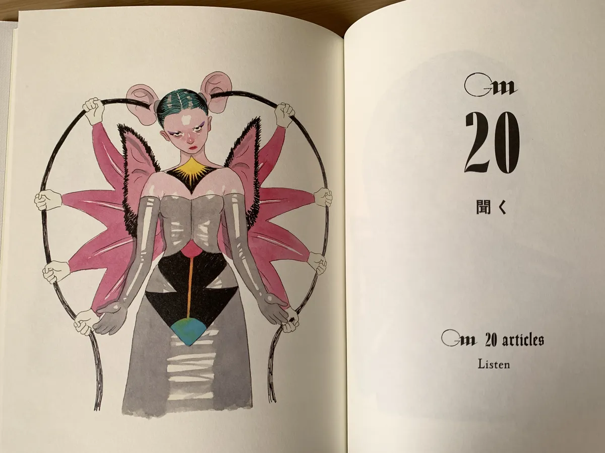 A page spread of a book. The left page contains a watercolor painting of a young woman looking menacing, with pigtails of giant human ears and wings that resembles bat ears. 8 arms emanate like a flower from her back, with each hand holding long hair coming out of each giant ear.