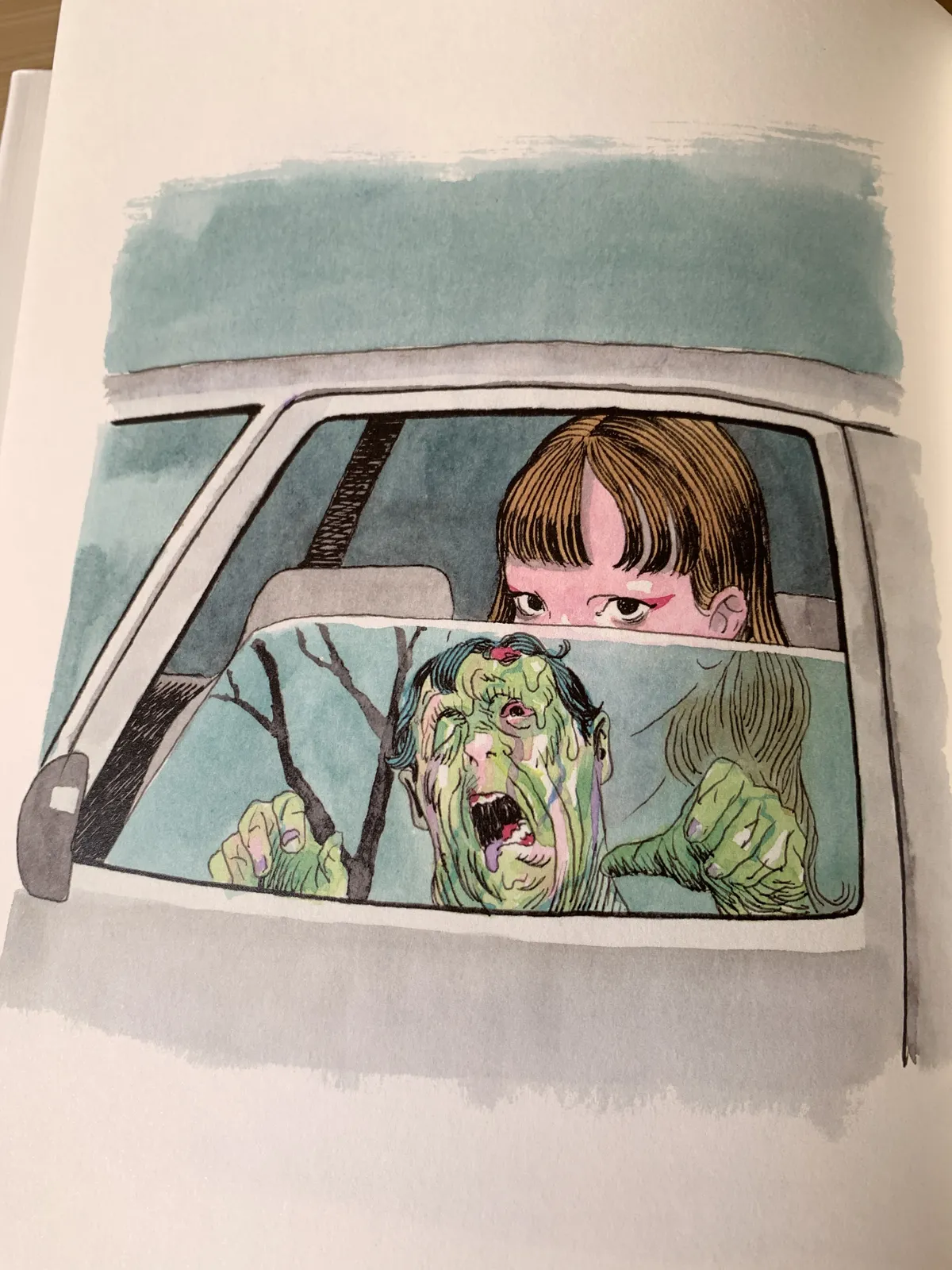 A page of a book containing a watercolor painting of a young woman in a car. The windows are half-open, showing only her eyes and a reflection of a green, oozing zombie coming for her.